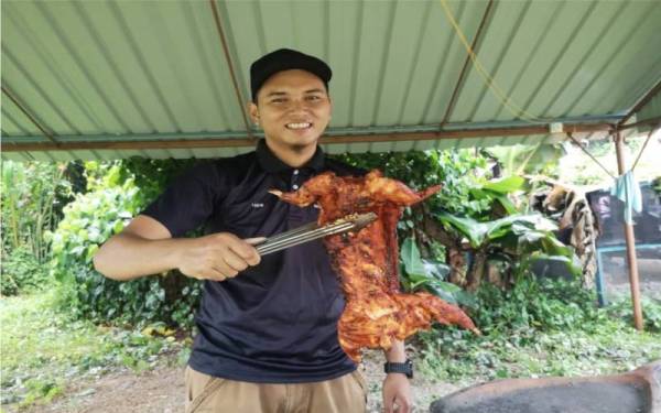 Wan Mohammad Muttaqim bersama arnab panggang madu yang telah masak di kediamannya di Kampung Rhu Muda, Marang.