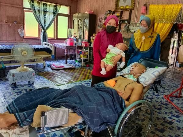 Nora (kanan) semasa melawat Siti Nor Shafika serta anak dan suami yang terlantar di Kampung Lubok Pukol, Kedai Baru, Kota Bharu.