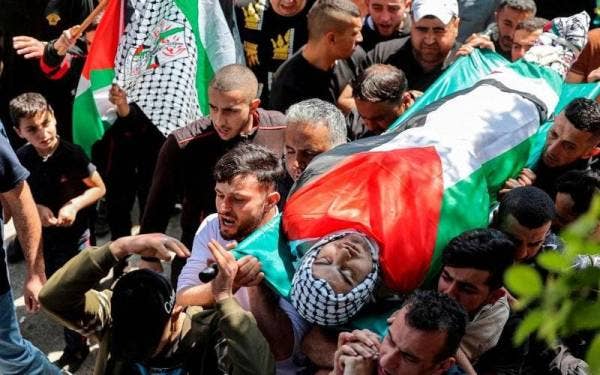 Orang ramai mengusung jenazah seorang peguam, Muhammad Hassan Muhammad Assaf di Tebing Barat pada Rabu. - Foto AFP