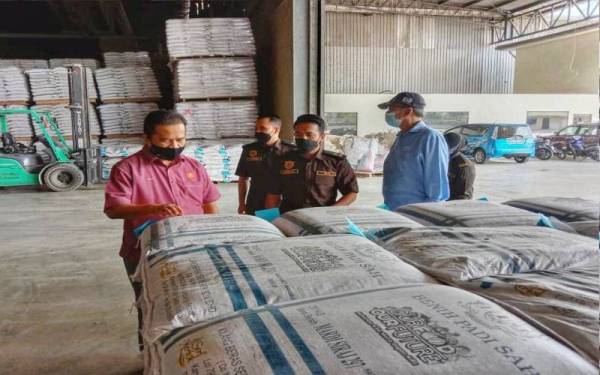 Abdul Rahman (tengah) bersama Azman (kiri) ketika membuat pemeriksaan di salah sebuah kilang pengeluar benih padi sah di sekitar negeri ini.