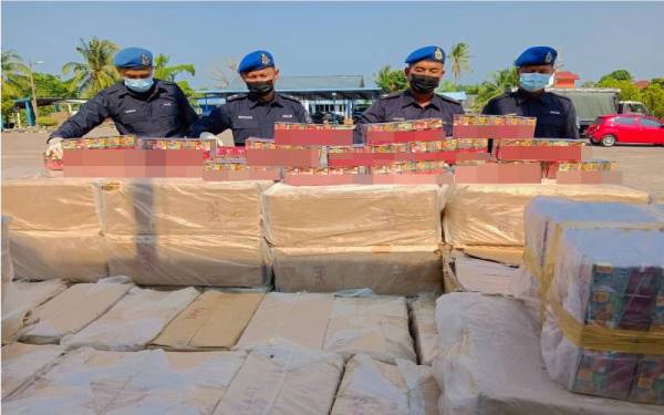 Azuhar (dua dari kanan) menunjukkan rokok putih bernilai RM600,000 yang diseludup masuk ke negara ini semasa umat Islam sedang bersiap sedia untuk bersahur pada Khamis.