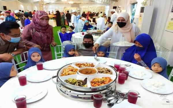 Faizul Rohban (tiga dari kiri di belakang) menyantuni anak-anak yatim yang hadir ke Majlis Kongsi Kaseh Bersama Kemudi anjuran syarikat pengeluar kopi Manja Qaseh dan Arjuna Qaseh iaitu FR Qaseh Marketing Sdn Bhd.