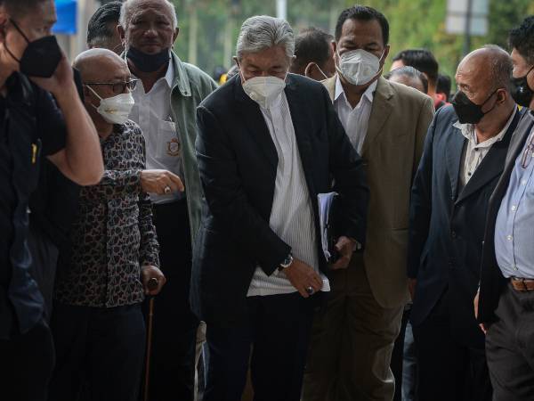 Ahmad Zahid (tengah) tiba di Kompleks Mahkamah Kuala Lumpur pada Jumaat untuk prosiding bela diri bagi 47 pertuduhan membabitkan pecah amanah, rasuah dan pengubahan wang haram berkaitan dana Yayasan Akalbudi yang dihadapi beliau. - Foto Bernama