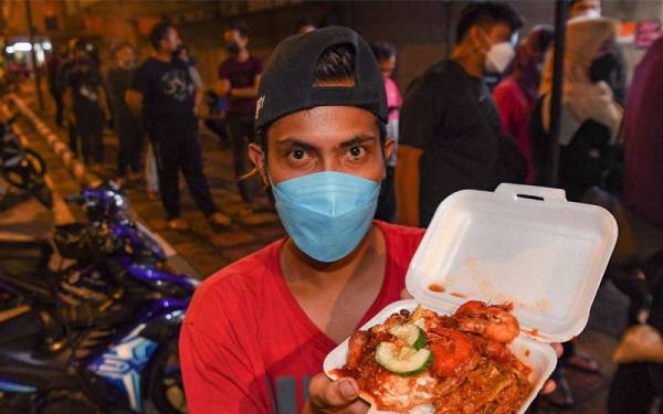 Tukang masak Mohamad Taufiq Mohamed Zamri, 28, menunjukkan nasi lemak yang dijual di premisnya di hadapan pasaraya The Store Ipoh ketika ditemui awal pagi tadi.
