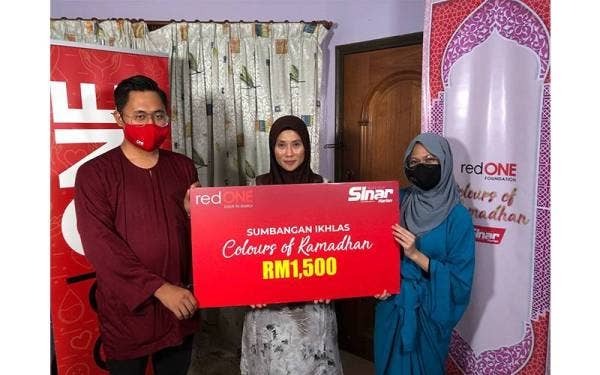 Herlina (tengah) menerima sumbangan wang tunai daripada wakil redONE.