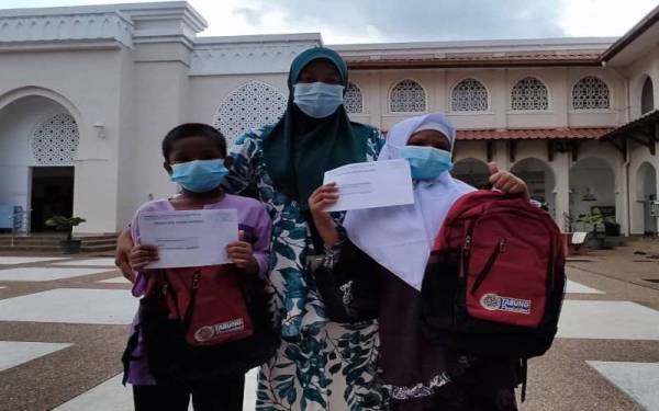 Aisyah (tengah) bersama dua cucunya, Alesya Maisarah dan Iskandar selepas pembukaan akaun Simpan SSPN Prime di Masjid Jame’al Shahab, Kepala Batas, Jitra.