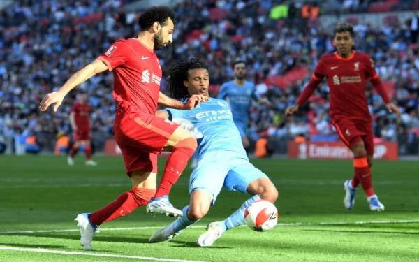 Penyerang Liverpool Mohamed Salah cuba melepas asakan daripada pemain City, Nathan Ake pada aksi separuh akhir berkenaan. - Foto EPA