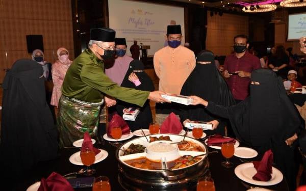 Annuar (dua, kiri) beramah mesra sambil menyampaikan sumbangan kepada pelajar dari Madrasah Tahfiz Fathur Rahman Jalan Taming Sari pada majlis Iftar Bersama Menteri Komunikasi dan Multimedia, pada Ahad.Foto Bernama

