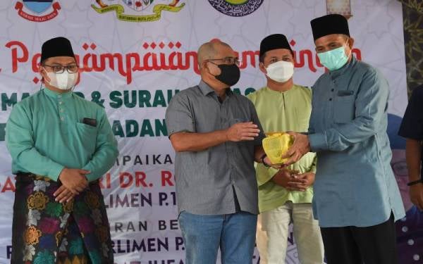 Ronald Kiandee (dua, kiri) menyampaikan sumbangan kepada wakil masjid dan surau kawasan Sugut pada majlis penyampaian sumbangan tersebut di Pejabat Daerah Kecil Paitan, pada Ahad. - Foto Bernama
 