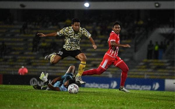 Pemain Perak FC, Royizzat Daud (tengah) mengawal bola ketika menentang Kelantan FC pada saingan Liga Premier di Stadium Perak.