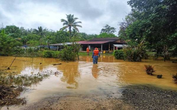 Petugas Angkatan Pertahanan Awam Malaysia (APM) Daerah Lipis membuat pemantuan di sekitar kawasan dinaiki air susulan hujan lebat berterusan, pada awal pagi Isnin. - Foto ihsan APM
