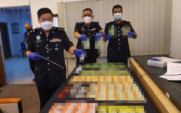 Chong Chern (kiri) menunjukkan dadah yang dirampas ketika sidang media di Ibu Pejabat Polis Daerah Seberang Perai Selatan pada Isnin.