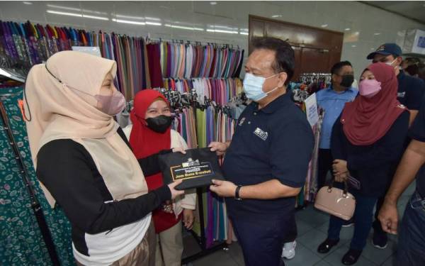 Alexander Nanta Linggi (kanan) menyantuni peniaga pada sesi Walkabout Program Jualan Malaysia di Kompleks Ujana Kewangan Labuan, pada Isnin. - Foto Bernama 