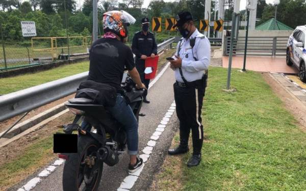 Anggota polis trafik memeriksa penunggang motosikal dalam Operasi Khas Samseng Jalanan. Foto JSPT Johor