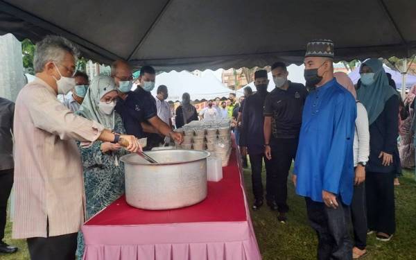 Al-Sultan Abdullah dan Tunku Azizah mengagihkan bubur lambuk kepada orang ramai yang datang berbuka di padang MBK1.