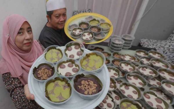 Siti Hasimah (kiri) dan suaminya, Amir (kanan) menunjukkan kuih tiga beradik yang dihasilkan secara kecil-kecilan di rumahnya di Taman Seri Inderapura di sini pada Rabu.