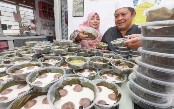 Siti Hasimah dan suaminya, Amir menunjukkan kuih tiga beradik yang siap dikukus.