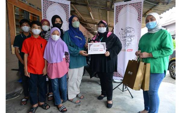 Rena Ajmal (tiga dari kanan) menerima sumbangan wang tunai daripada Norazian (dua dari kanan) di rumahnya di Kampung Tengah Baru 13.