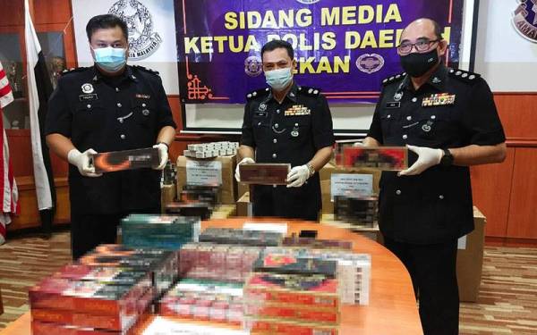Mohd Zaidi (tengah) bersama dua pegawainya menunjukkan bekalan rokok seludup yang dirampas daripada suspek hasil serbuan ke atas sebuah rumah di Felda Chini 2, Isnin lalu.
