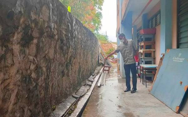 Taufik menunjukkan tembok yang telah retak dan menunggu masa untuk runtuh.