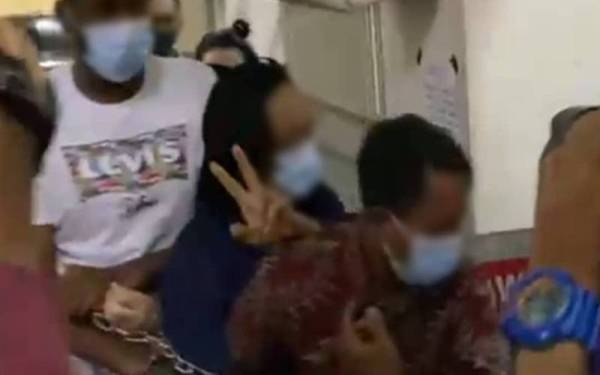 Seorang vokalis sebuah kumpulan terkenal (tengah) dibawa ke Mahkamah Majistret Petaling Jaya pada Jumaat.