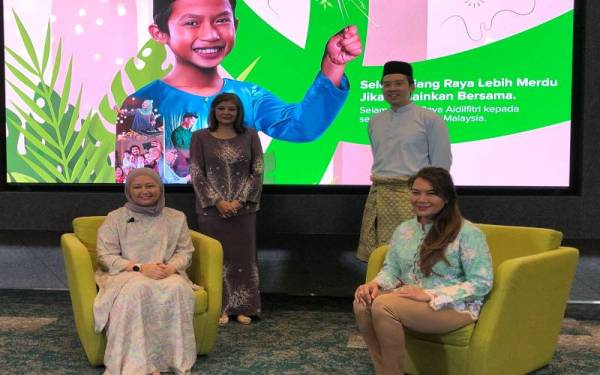 Kam Leong (berdiri, kanan) bersama Ras Adiba (duduk, kanan) pada Majlis Pelancaran Kempen Riang Raya Maxis di Kuala Lumpur pada Khamis.