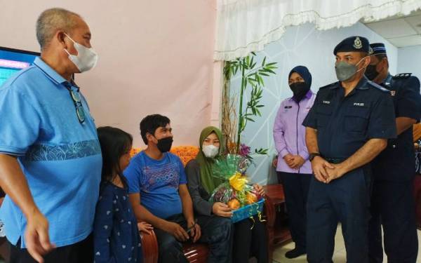 Mohd Uzir (kanan) ketika mengadakan lawatan ke kediaman keluarga Mohd Fazlan Nizam di Taman Tasek Putra, Tronoh pada Jumaat.