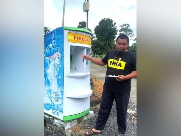 Mohd Khairul Azman menunjukkan mesin penapis air percuma yang dirosakkan dipercayai diletupkan oleh seorang pemuda dengan menggunakan mercun, pada Khamis.