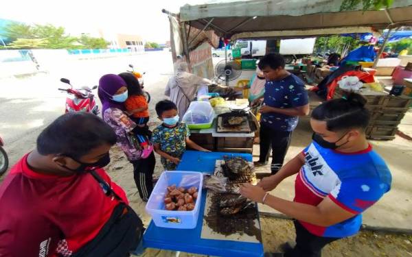 Orang ramai memenuhi gerai Muhamad Shafian seawal jam 3 petang untuk mendapatkan ikan cencaru bakar sumbat RM1.50 seekor.