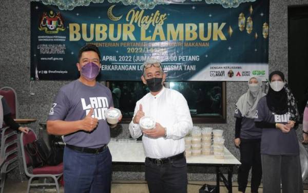 Badrul Hisham (kiri) bersama Tengku Ahmad Badli Shah menunjukkan bubur lambuk yang akan diagihkan kepada warga MAFI.