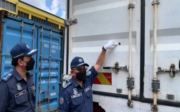 Abdul Latif (dua dari kanan) menunjukkan kesan lubang tembakan yang mengenai lori berkenaan.