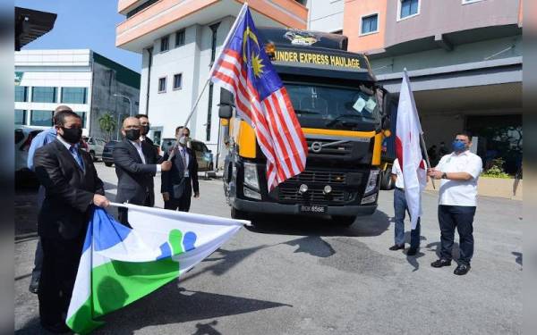 Ronald (dua dari kiri) menyempurnakan gimik pelepasan pada Majlis Flag Off Pengeksportan Produk Agromakanan ke Jepun yang berlangsung di Ibu Pejabat FAMA, Selayang pada Jumaat. Turut sama Mohamad Mustahapa (kiri).