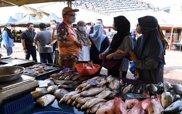 Ir Izham (tengah) bertemu pengunjung pasar tani selepas mengadakan sidang akhbar khas Karnival Jualan Mega Prihatin sempena musim perayaan Aidilfitri di Pasar Tani Seksyen 13 pada Ahad. - Foto Bernama