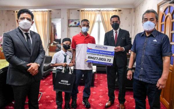 Abdul Muie (dua, kanan) menyerahkan khairat kematian kepada Othman (tiga, kiri) pada Majlis Penyampaian Khairat Kematian Ahli Skim 18 di Pejabat Pendidikan Daerah Kuala Terengganu pada Ahad. - Foto Bernama