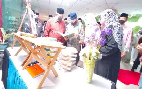 Sultan Sharafuddin diiringi Tengku Permaisuri Norashikin mencemar duli melawat ruang pameran bersama Abdul Latiff (kiri).