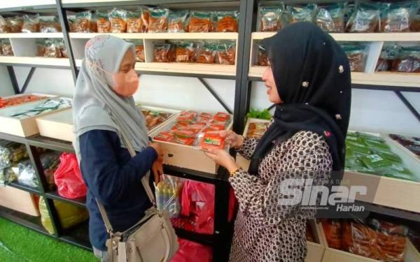 Nor Fatin Nabila (kanan) melayan pelanggan yang datang ke kedai bagi mendapatkan gelembung buaya.