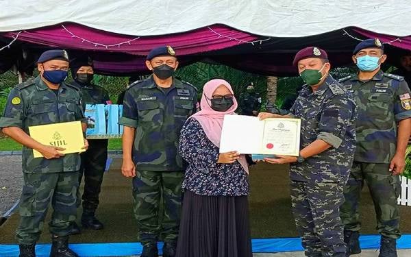 Hazani (dua dari kanan) menyampaikan sijil penghargaan kepada Ketua Wartawan Sinar Harian Kelantan, Hazelen Liana Kamarudin sebagai penghargaan kepada media Kelantan atas liputan yang diberikan kepada penugasan kawalan sempadan Malaysia-Thailand menerusi Op Wawasan Kelantan.