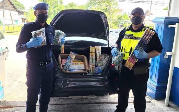 Dua anggota PPMW2 menunjukkan mercun dan bunga api yang dijumpai dalam kereta milik suspek.