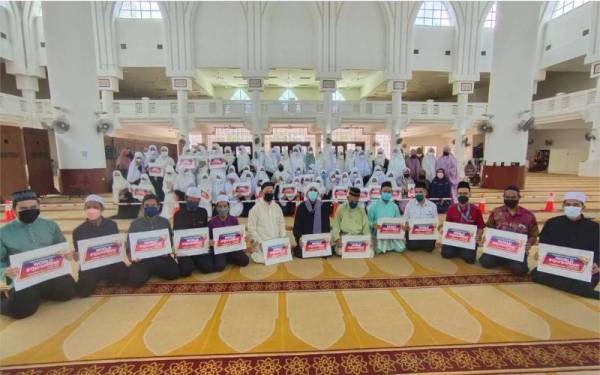 Dr Hasbullah (depan, lima dari kanan) dan Dr Azmi (depan, enam dari kiri) bersama peserta yang mengambil bahagian dalam Program Iktikaf Perdana dan World #QuranHour di Masjid Sultan Haji Ahmad Shah,UIAM Kuantan pada Selasa.