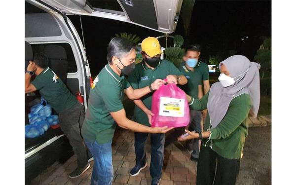 Khaliq Mehtab membantu kakitangannya mengangkat pek makanan yang akan diedarkan kepada petugas barisan hadapan di beberapa agensi kerajaan sekitar Pulau Pinang.