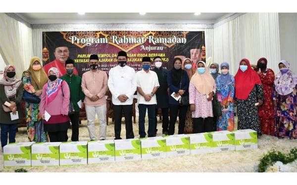 Mohd Salim bergambar bersama para penerima pada majlis penyerahan bantuan ‘Program Rahmat Ramadhan 2022’ di Dewan D’Zahra.