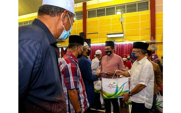 Mohd Salim (dua dari kanan) dan Abdullah (kanan) menyampaikan bantuan kepada imam-imam.