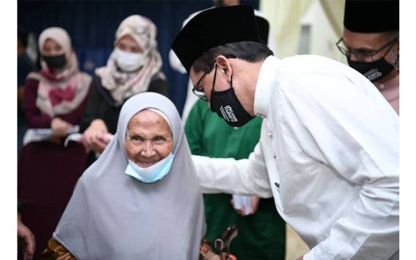 Senyuman ceria penerima sumbangan RM150 daripada RISDA di Dewan D’Zahra.