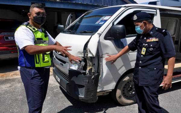 Abdul Rozak (kiri) menunjukkan kesan kemek pada tepi kiri van yang ditahan kerana disyaki membawa mercun seludup di Kampung Alor Keladi, Hulu Besut pada pagi Selasa. - Foto Bernama
