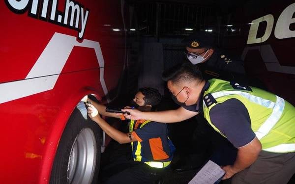 Muhammad Firdaus (tengah) melihat anggota dan pegawainya memeriksa tayar bas ekspres bagi memastikan penggunaannya mengikut piawaian ditetapkan ketika pemeriksaan bas di depoh sempena Op Hari Raya Aidilfitri 2022 di Malim Jaya pada Selasa. - Foto Bernam