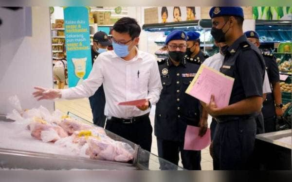 Thing Han (kiri) bersama pegawai serta penguat kuasa KPDNHEP Johor meninjau harga ayam selepas melancarkan Skim Harga Maksimum Musim Perayaan Hari Raya Puasa 2022 di sebuah pasar raya dalam KSL City Mall, Johor Bahru pada Selasa.