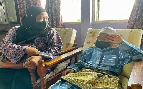 Aslimi bersama anaknya ketika ditemui selepas menerima sumbangan daripada Yusof di PDK Sipitang.