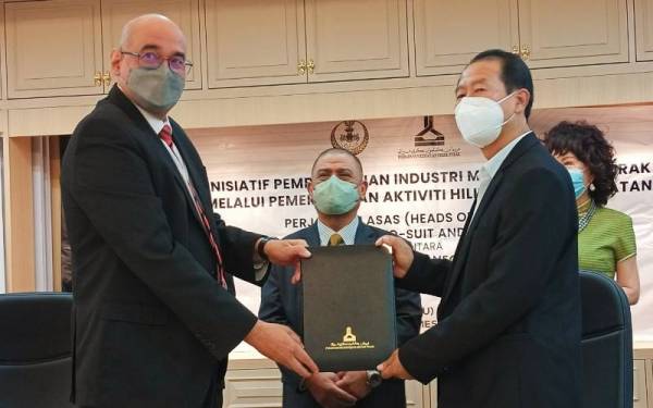 Saarani (tengah) menyaksikan majlis menandatangani BTSL antara Redza Rafiq (kiri) dengan Wenchuan di Bangunan Perak Darul Ridzuan, Ipoh pada Rabu.