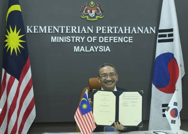 Hishammuddin menunjukkan dokumen selepas menandatangani memorandum persefahaman berkenaan Aspek Industri Pertahanan bersama Menteri Pertahanan Nasional Republik Korea Selatan Suh Wook di Wisma Pertahanan hari ini. -Foto Bernama
