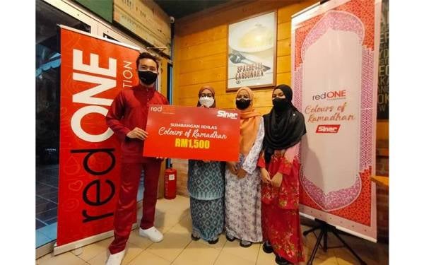 Mohd Fazrin menyerahkan sumbangan kepada Nurmarzarina dan adik-adiknya.